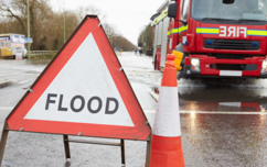 Flood sign with fire ambulance in the background