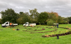 Grounds maintenance team planting in the covid memorial garden