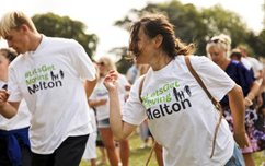 People moving in the park at lets get moving melton day, in branded t-shirts, having fun