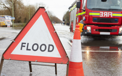 Flood sign with fire ambulance in the background