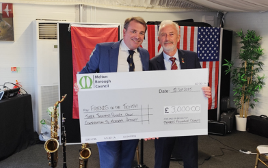 Cllr Higgins handing over a cheque to community group