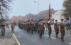 Military personnel marching down Sage Cross Street